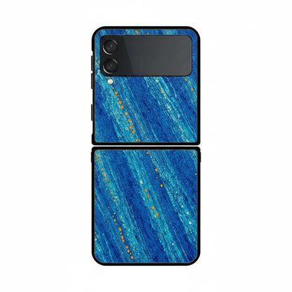 Inspiring Phone Cases Cobalt Drift Samsung Galaxy Z Flip case with blue abstract strokes and orange accent flecks.